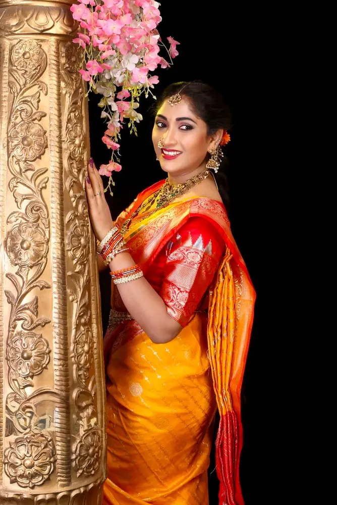 Portrait of a woman in a red and gold silk saree
