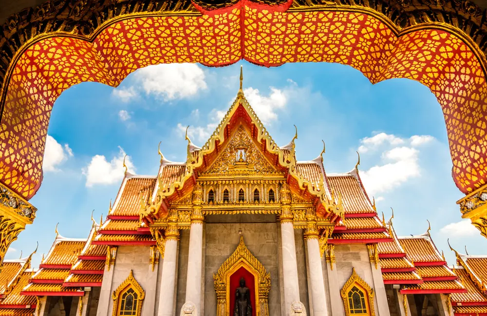 Ornate golden temple seen through a decorative arch